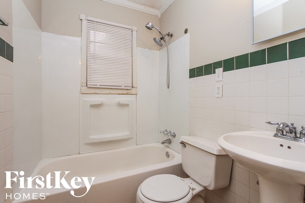 a bathroom with a toilet sink and bath tub and a sink and a mirror