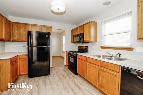 a kitchen with black appliances and wooden cabinets