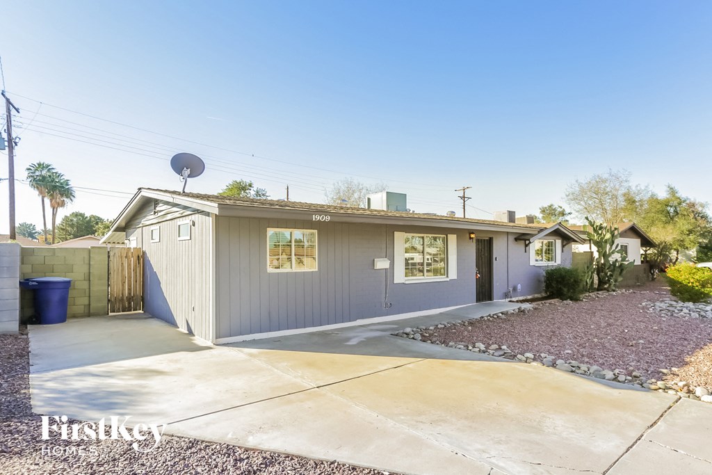 A house with a grey exterior and a satellite dish on the roof.