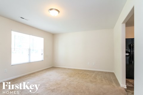 A room with a carpeted floor and a window letting in natural light.