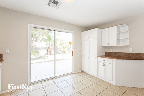 A kitchen with white cabinets and a brown countertop.