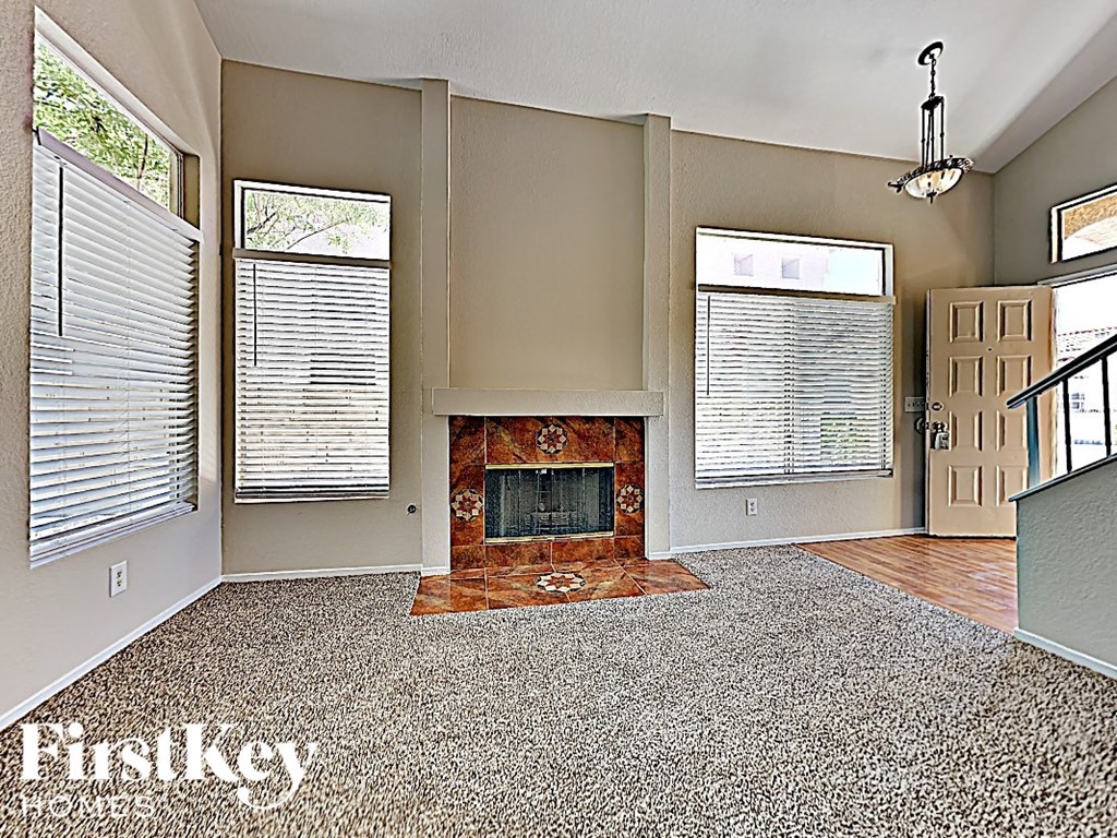 A living room with a fireplace and a rug.
