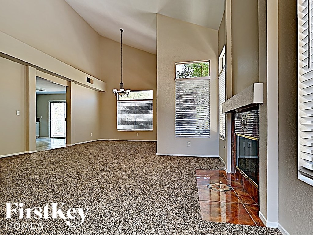 A room with a carpet and a fireplace.