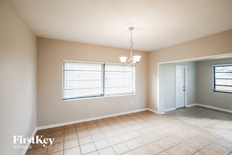 a dining room with a large window and a tiled floor