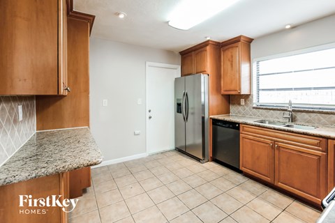 a kitchen with wooden cabinets and a stainless steel refrigerator