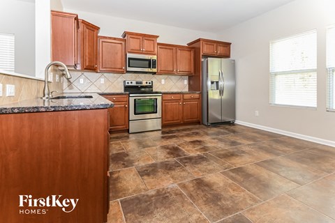 A kitchen with brown cabinets and a tile floor.