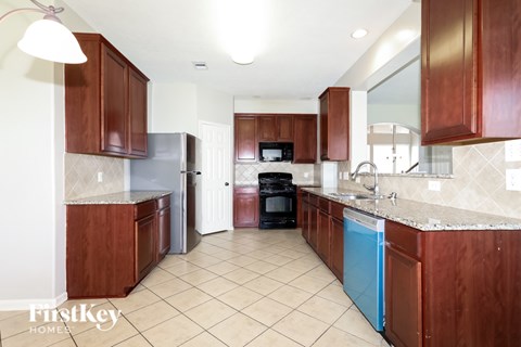 A kitchen with brown cabinets and a blue dishwasher.