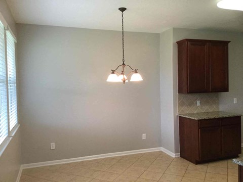 A kitchen with a brown cabinet and a hanging light fixture.
