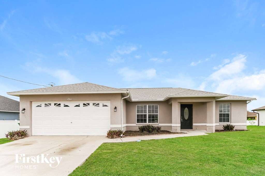 a beige house with a lawn in front of it