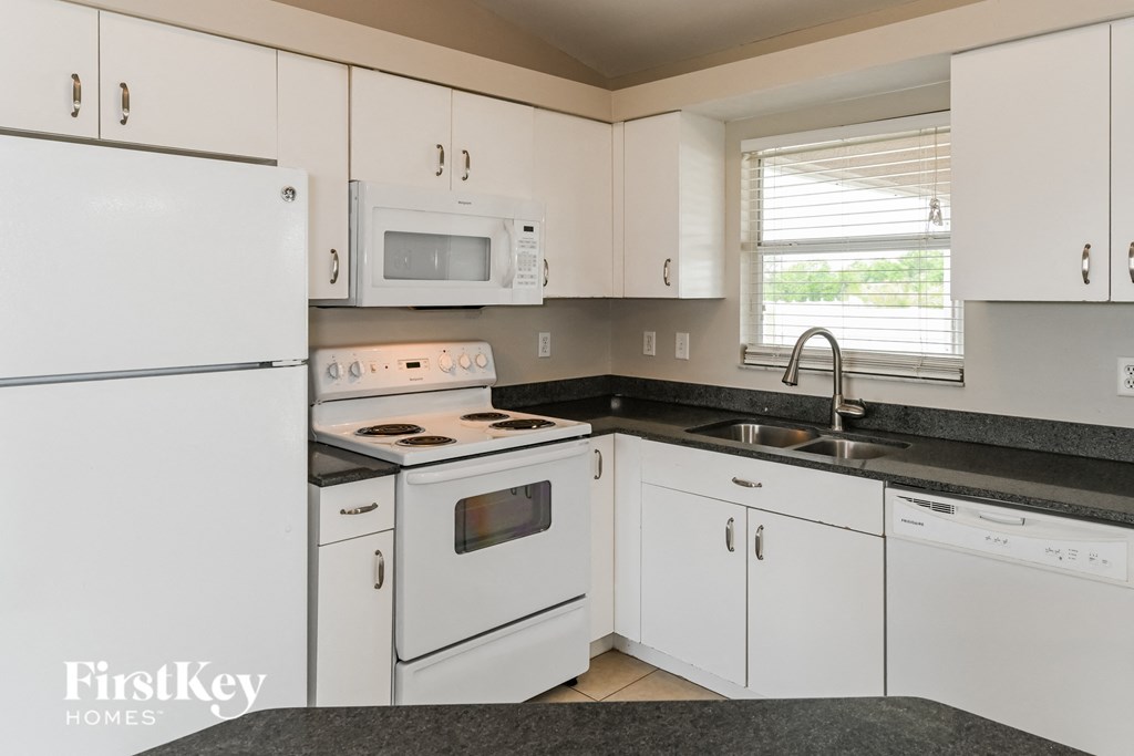 a kitchen with white appliances and white cabinets