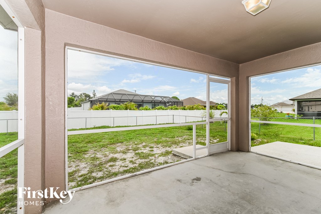 a patio with a view of a yard and a house