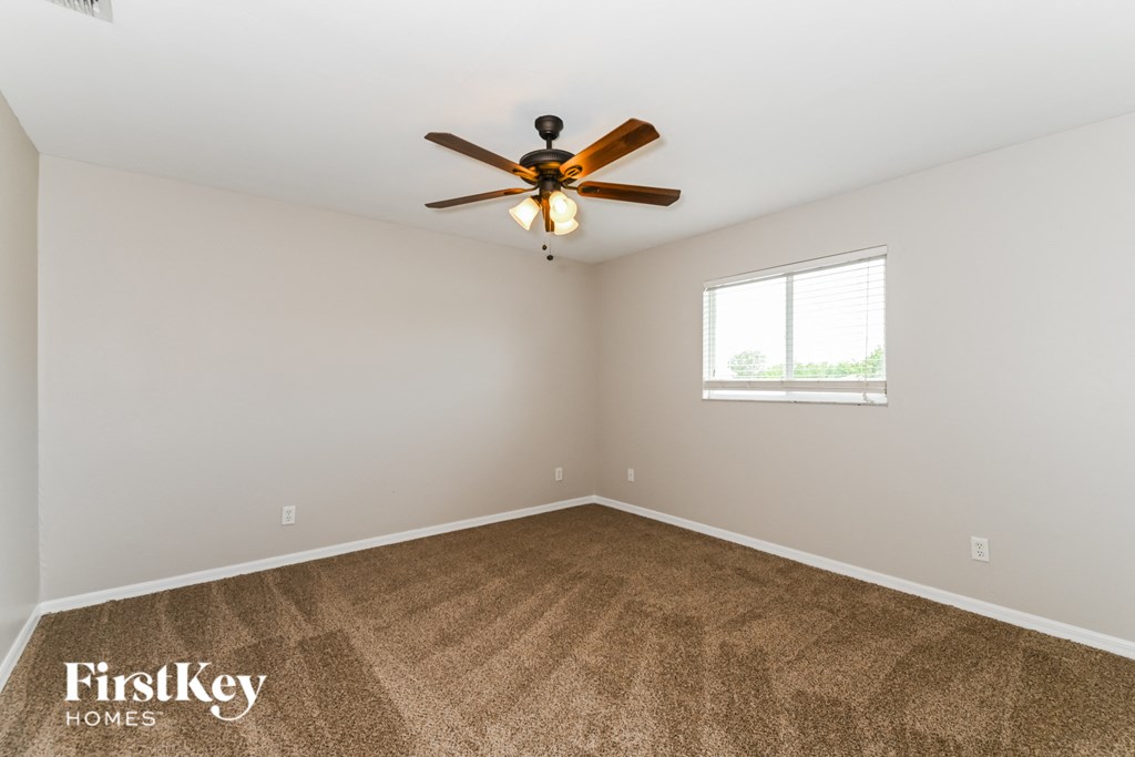 the living room is clean and ready to use with a ceiling fan