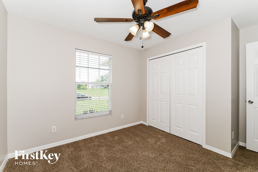 the master bedroom has a ceiling fan and carpeted flooring