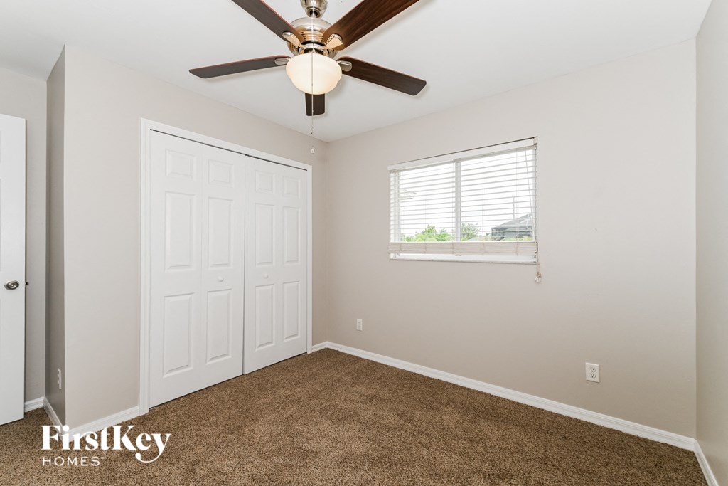 a bedroom with a ceiling fan and a window