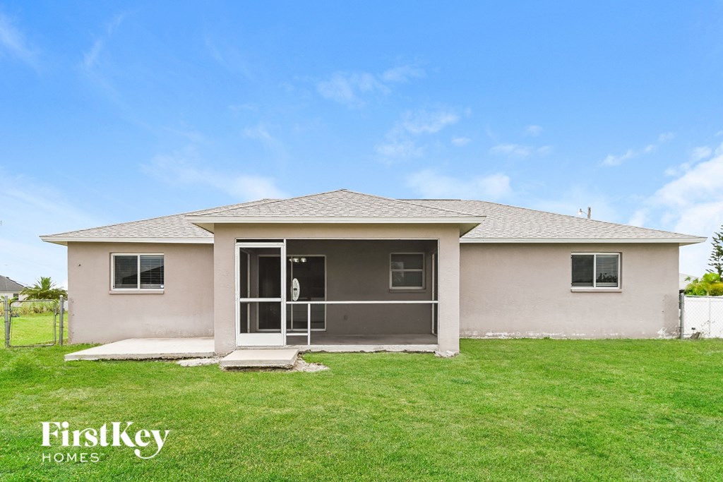 a beige house with a lawn and a blue sky