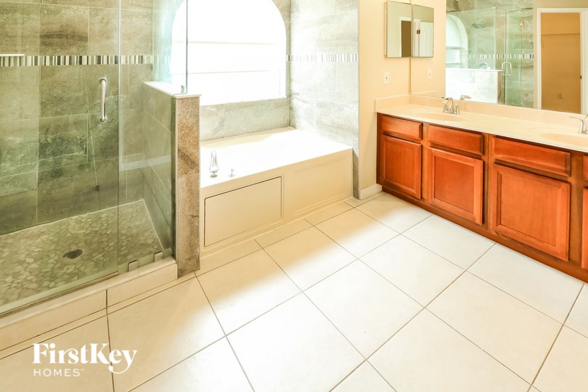 A bathroom with a walk-in shower and a double sink vanity.