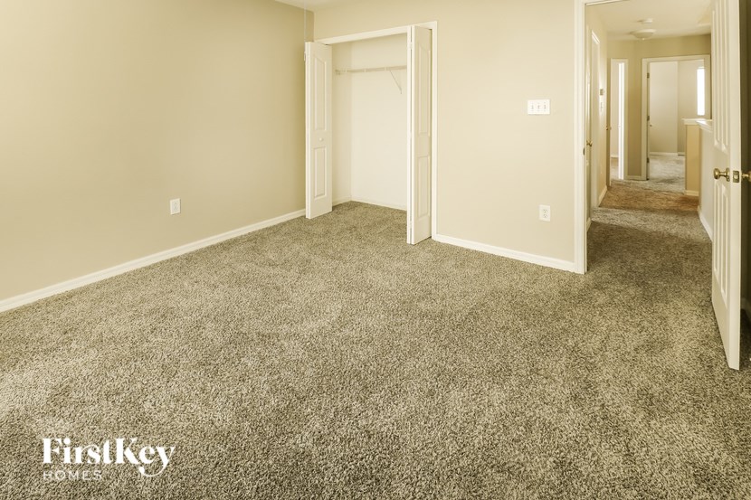 A room with a carpeted floor and two doors.