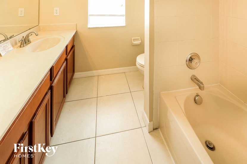 A bathroom with a tub, sink, and toilet.