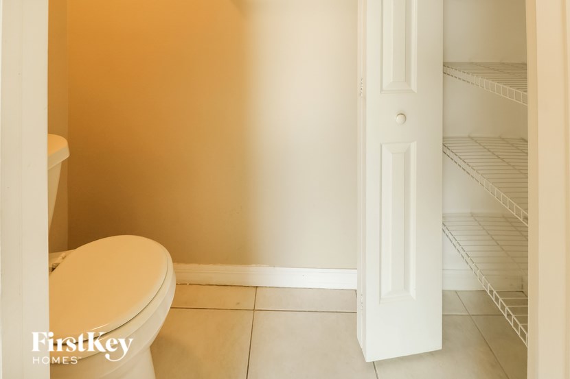 A white toilet in a bathroom with a white door.