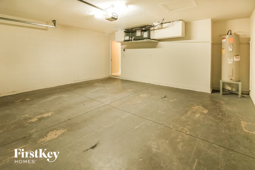 A large empty room with a concrete floor and a white wall.