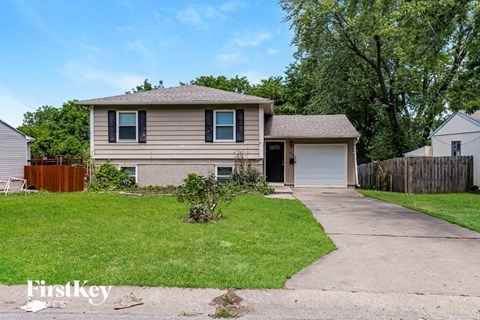 a small house with a yard and a driveway