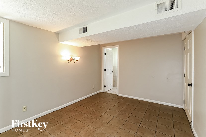 the living room and dining room of a house with a tile floor