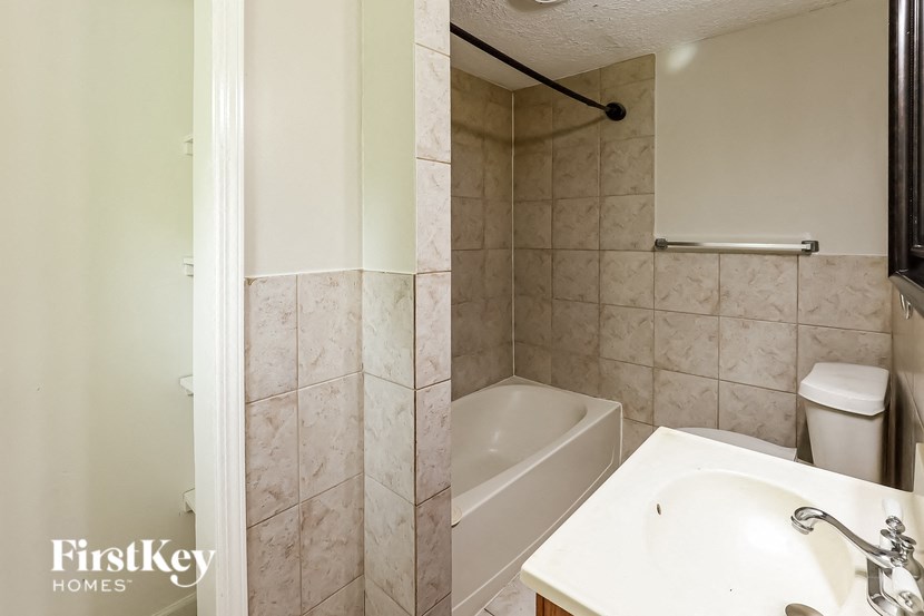 a bathroom with a tub and a sink and a mirror