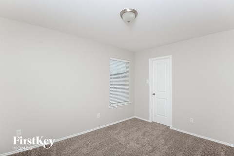 a bedroom with white walls and carpet and a white door