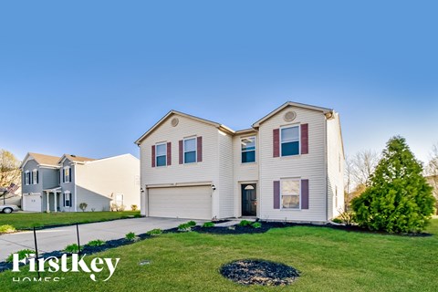 A large, two-story house with a garage is showcased in the image.