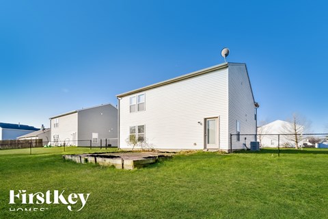 A house with a white exterior and a grey roof is shown with the text "FirstKey Homes" in the foreground.