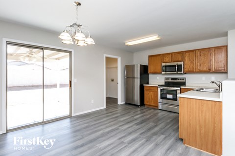 A kitchen with wooden cabinets and a stainless steel refrigerator.