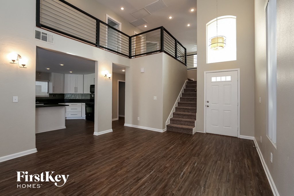 an open living room with a staircase and a kitchen