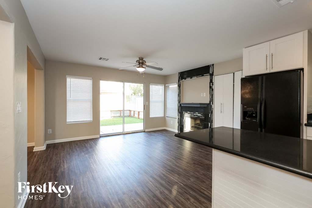 an empty kitchen with a black refrigerator and a black counter top