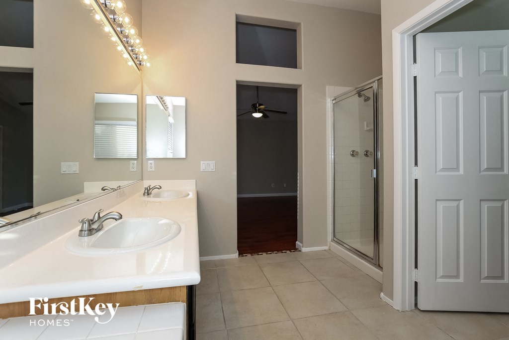a bathroom with a sink and a shower and a mirror
