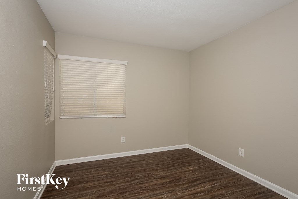 a bedroom with a hard wood floor and a window