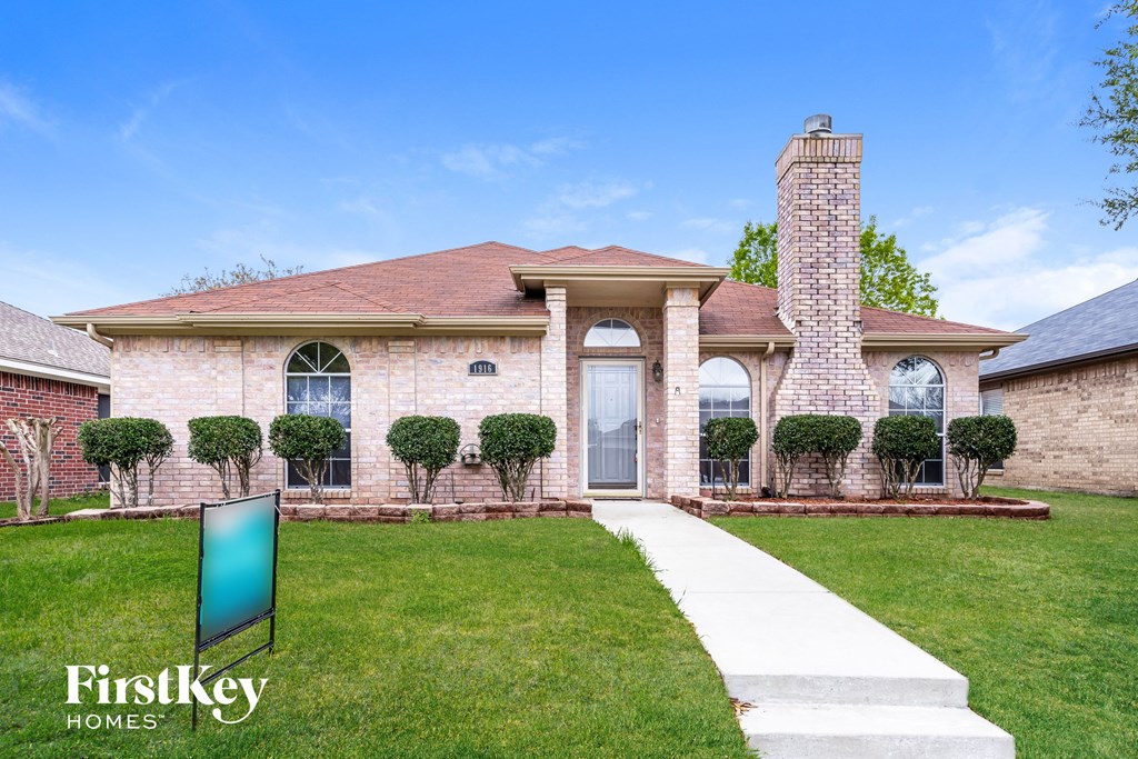 a home with a lawn and a walkway to the front door