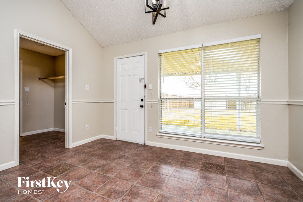 the living room of a home with a large window and a door to a closet