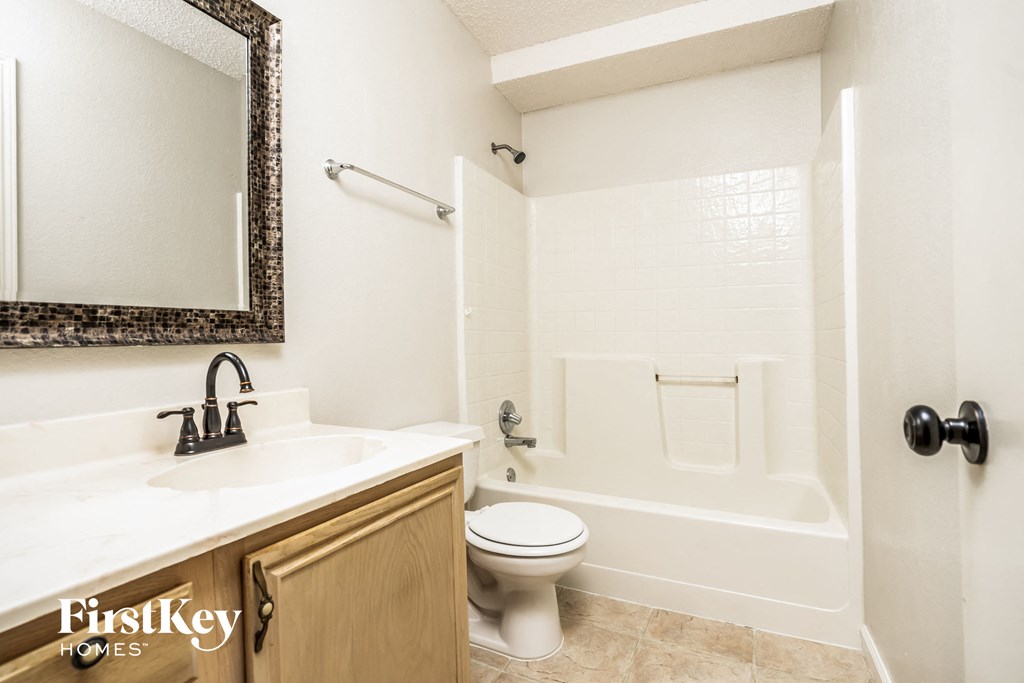 a bathroom with a toilet and a sink and a bath tub