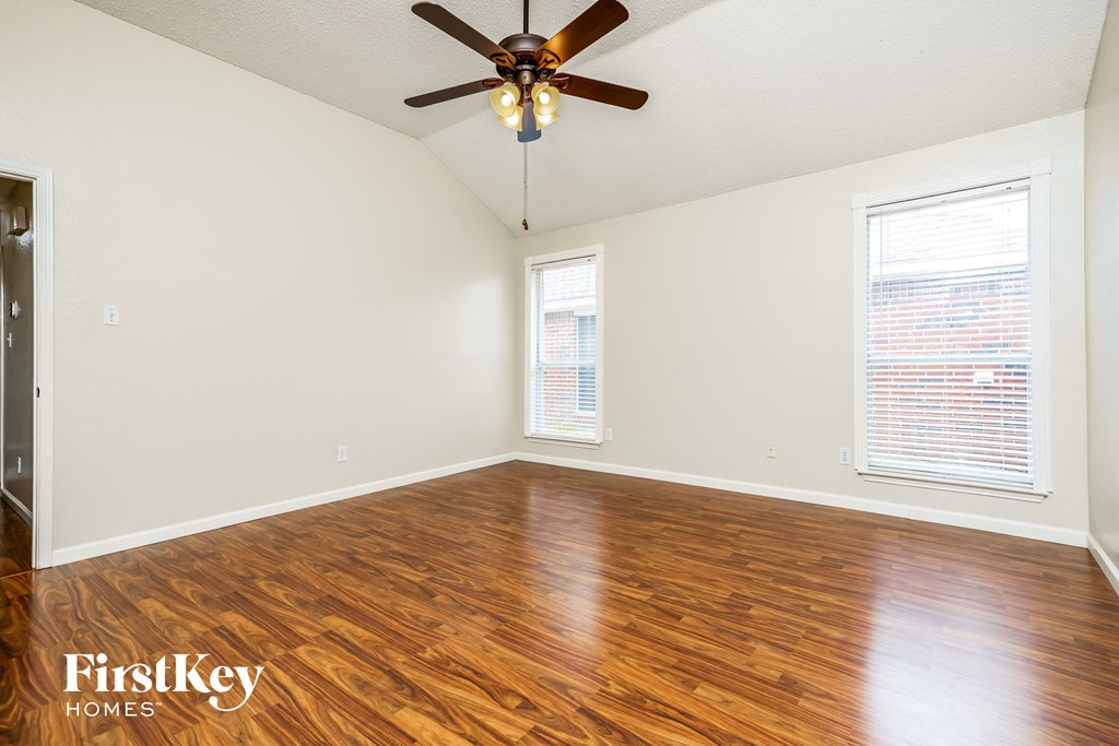 the living room with wood floors and a ceiling fan