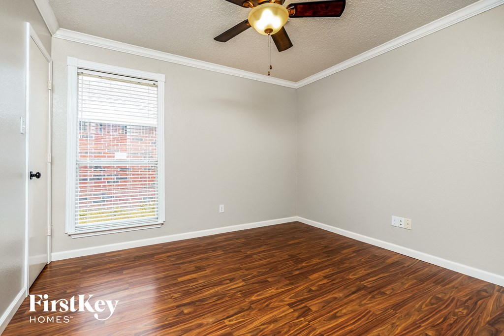 the living room of a home with wood flooring and a ceiling fan