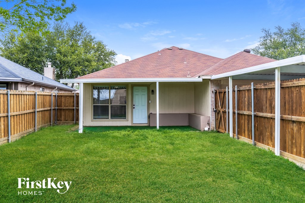 a backyard with a privacy fence and a porch