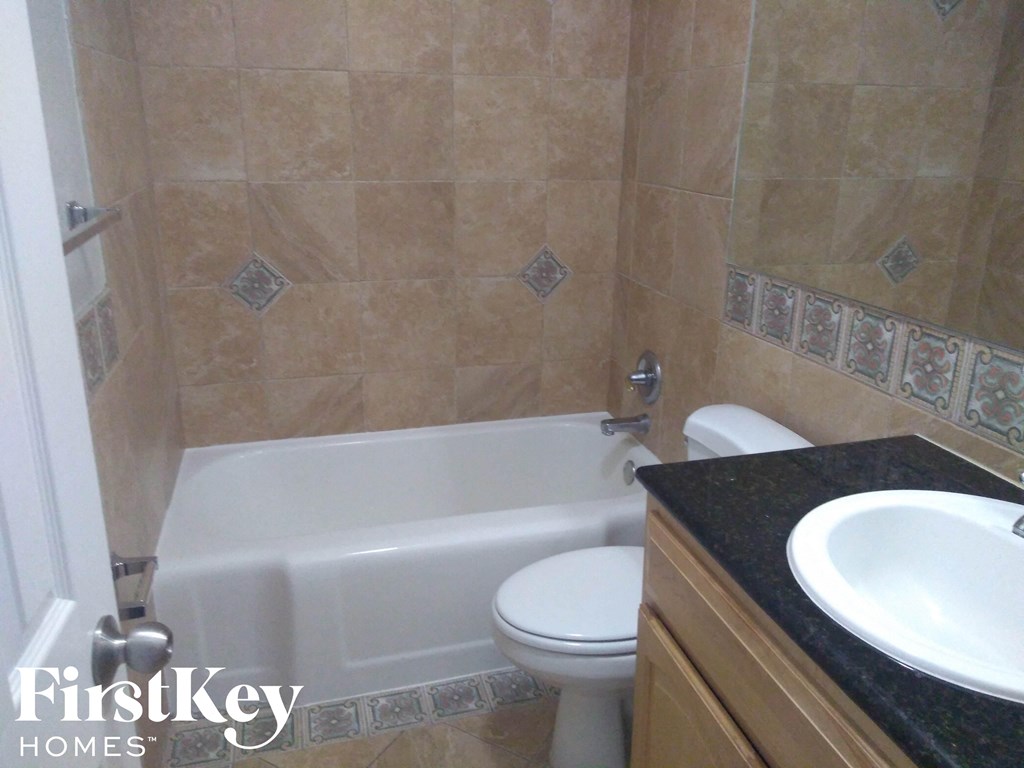 A bathroom with a tiled shower and a white toilet.