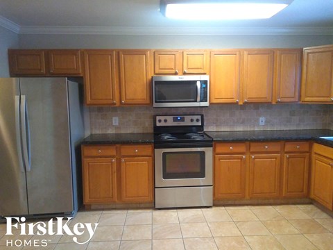A kitchen with wooden cabinets and a stainless steel refrigerator.