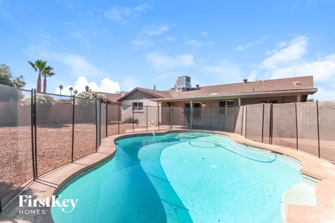 A pool in a backyard with a fence around it.