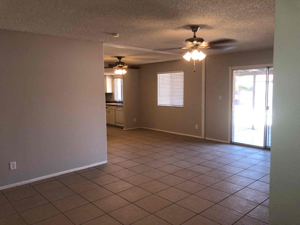 A room with a ceiling fan and tile flooring.