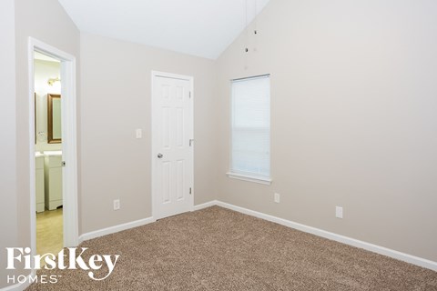 a bedroom with a carpeted floor and a white door