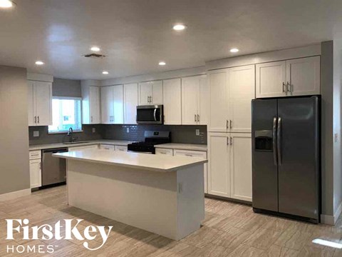 an updated kitchen with white cabinets and stainless steel appliances