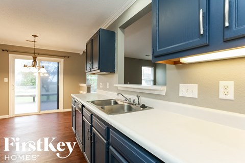 A kitchen with dark blue cabinets and a white countertop.