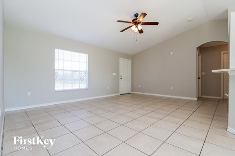 A spacious room with a ceiling fan and tiled flooring.