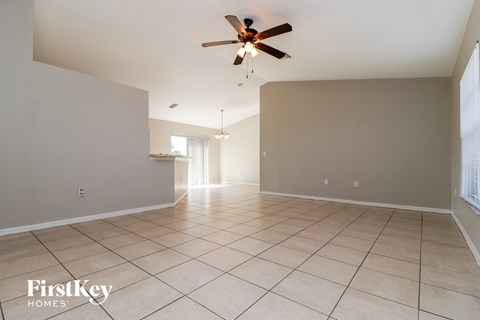 A spacious room with a ceiling fan and tiled flooring.